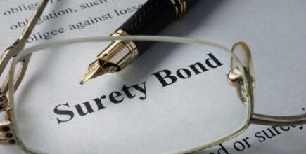 Eyeglasses on a piece of paper, magnifying the phrase 'surety bond'